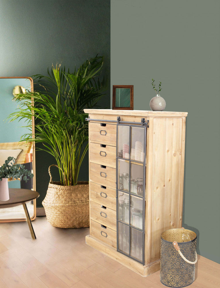 Ambientazione della cassettiera in una stanza con pareti verdi e piante decorative.