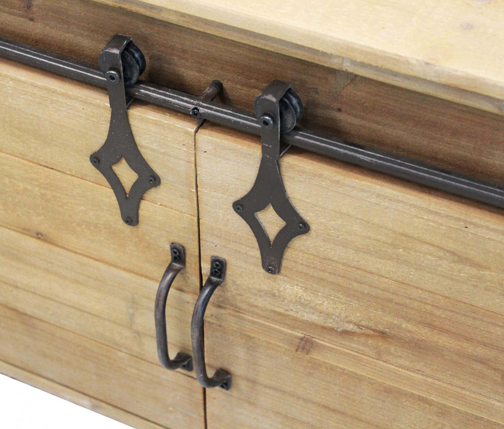 Primo piano delle maniglie in metallo forgiato e del meccanismo a puleggia per lo scorrimento delle ante in legno.
