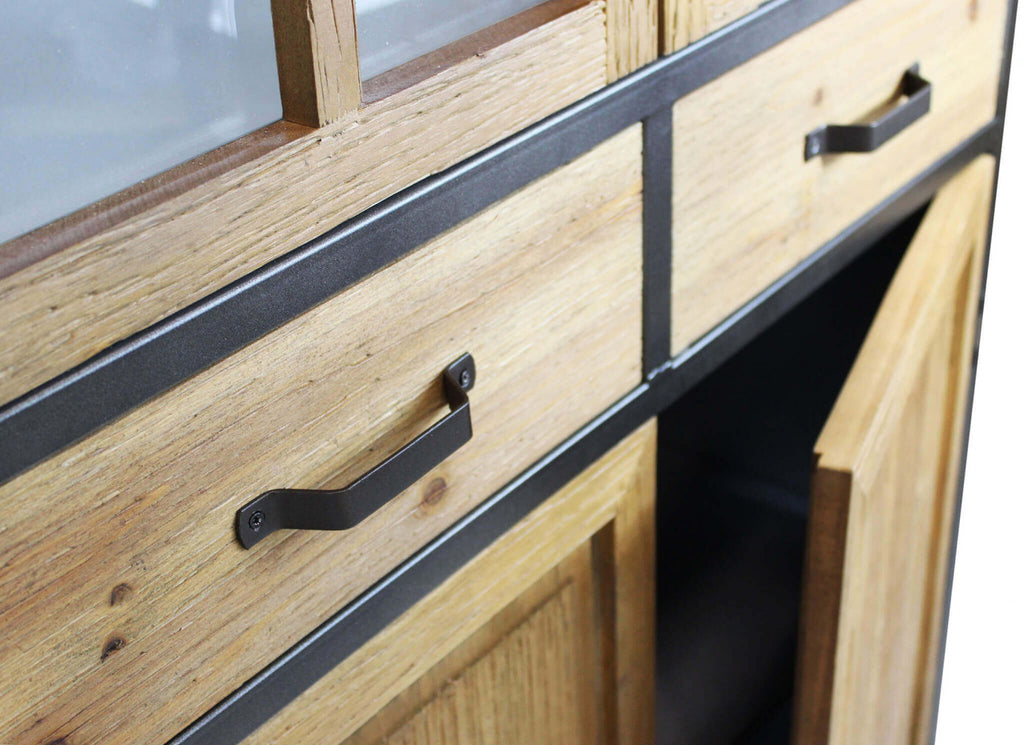 Dettaglio dei cassetti centrali in legno con maniglie in metallo scuro dal design industriale.