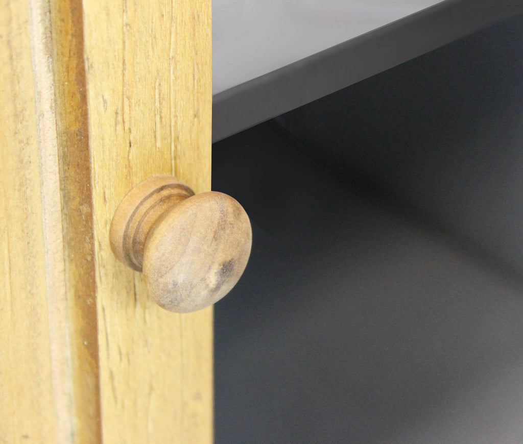 Particolare del pomello in legno tornito sull'anta inferiore della credenza.