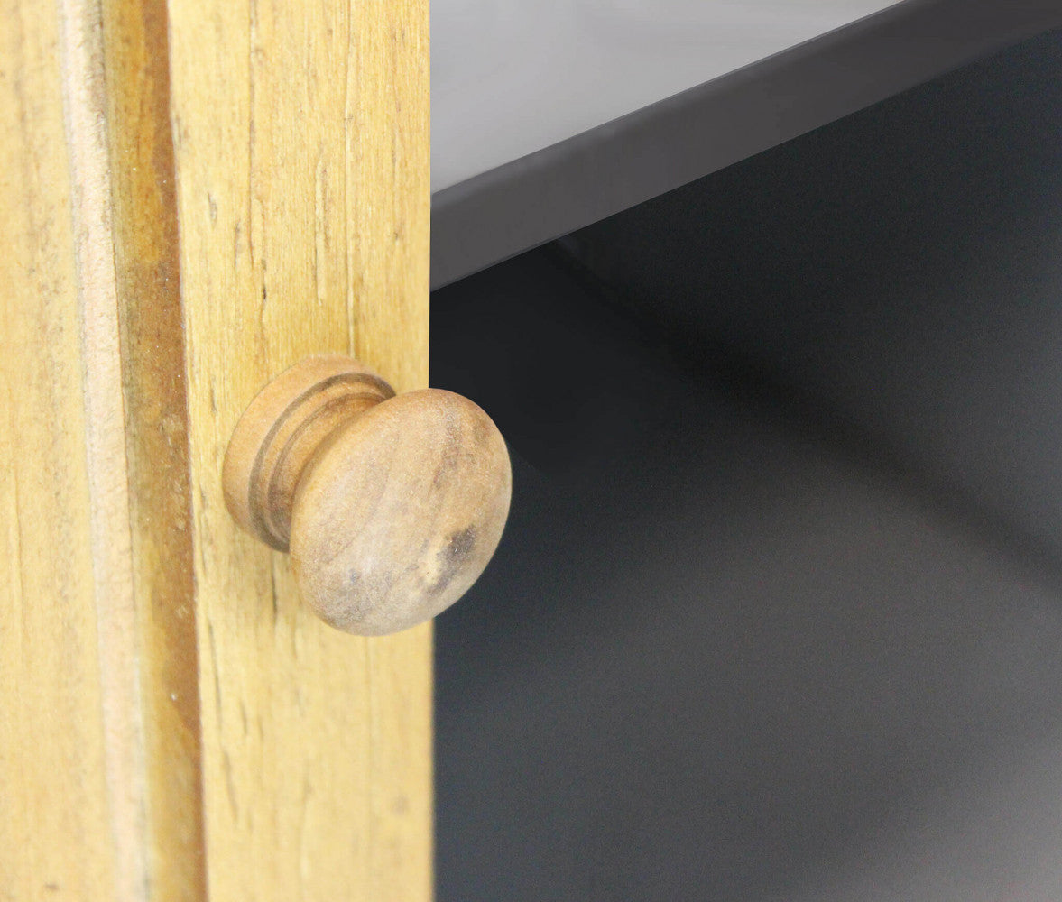 Particolare del pomello in legno tornito sull'anta inferiore della credenza.