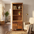 Libreria David in stile arte povera ambientata in un soggiorno luminoso con poltrona beige.