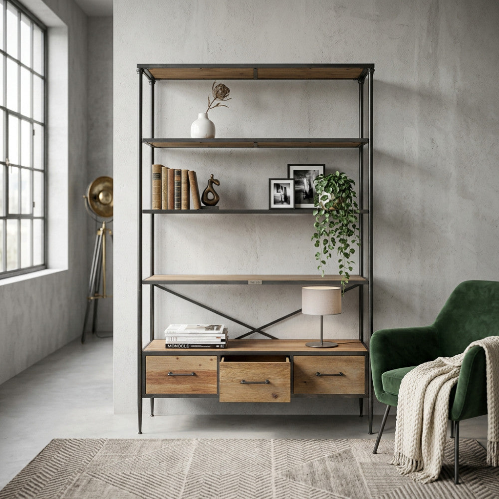 Libreria Delmar in legno e metallo ambientata in un salotto moderno con poltrona in velluto verde.