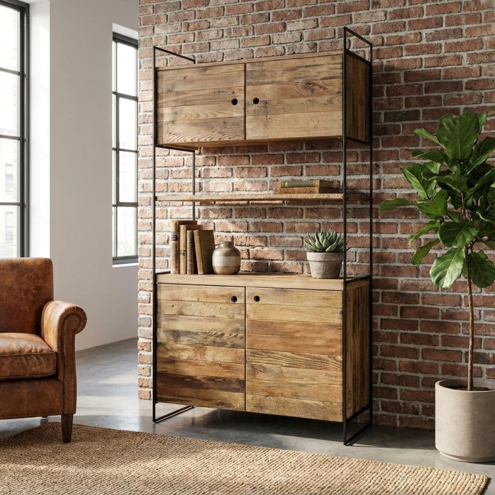 La credenza alta Dennis posizionata contro un muro di mattoni a vista, esaltandone l'estetica industriale e vintage.