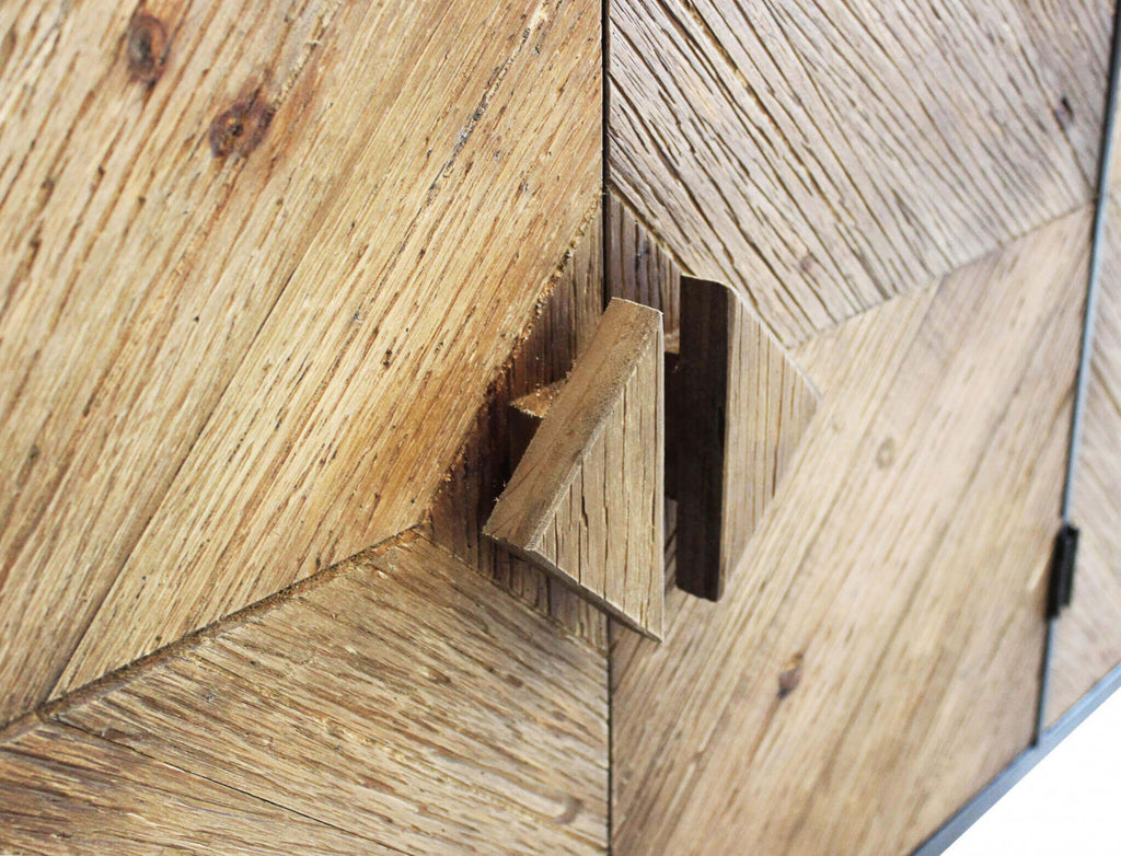 Dettaglio ravvicinato delle ante in legno della Credenza Derek, con focus sulla venatura tattile e sulle esclusive maniglie triangolari.