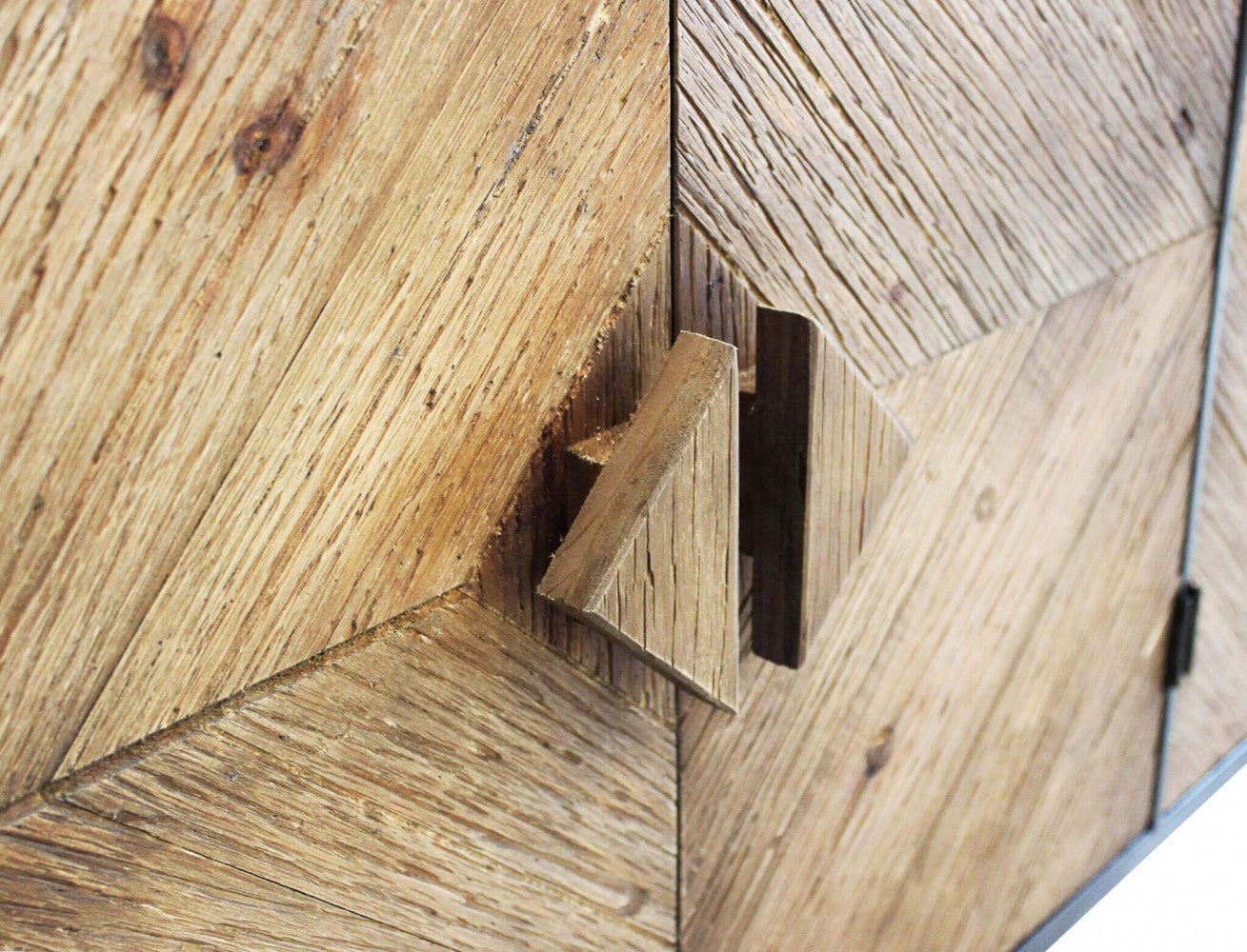 Dettaglio ravvicinato delle ante in legno della Credenza Derek, con focus sulla venatura tattile e sulle esclusive maniglie triangolari.