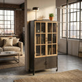 Vetrina Derick in legno e metallo nero ambientata in un loft industriale con divano beige.