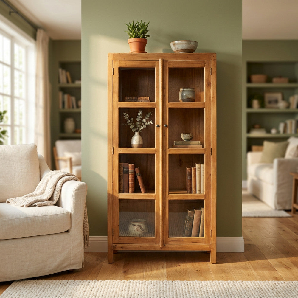 Credenza vetrina Douglas in legno marrone inserita in un salotto luminoso con divano chiaro.