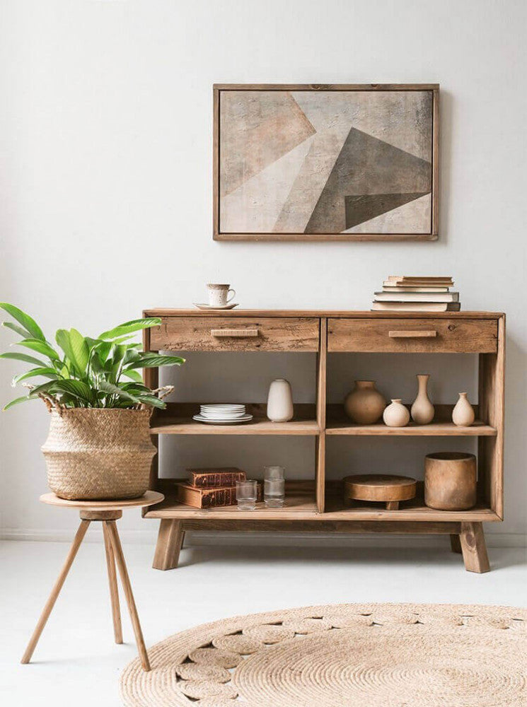Styling d'interni con la credenza Mobile Dylan, arricchita da vasi scultorei in terracotta, libri antichi e una pianta verde su sgabello.