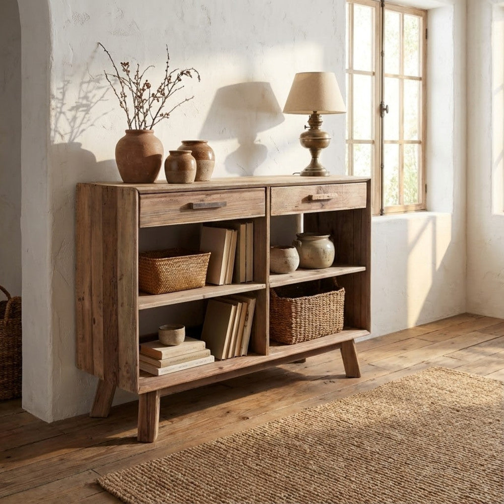 Atmosfera calda e accogliente con la credenza in pino riciclato illuminata dalla luce naturale di una finestra, affiancata da anfore rustiche.