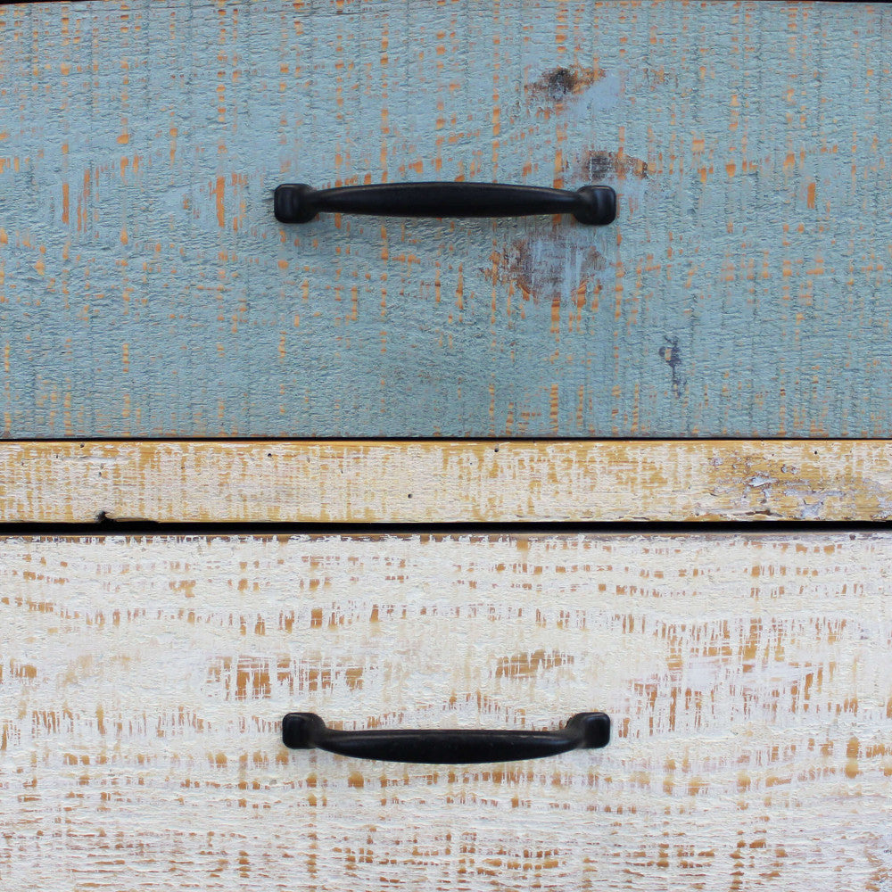 Primo piano dei cassetti multicolor, evidenziando la texture ruvida e la verniciatura decapé.