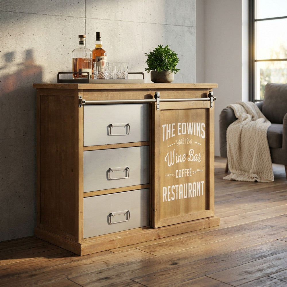 Mobile bar Ellery con anta scorrevole in legno e cassetti in metallo in un ambiente luminoso.