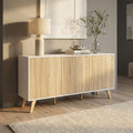 Credenza Elton in truciolare bilaminato bianco e naturale, ambientata in un soggiorno luminoso con lampada e vaso decorativo.