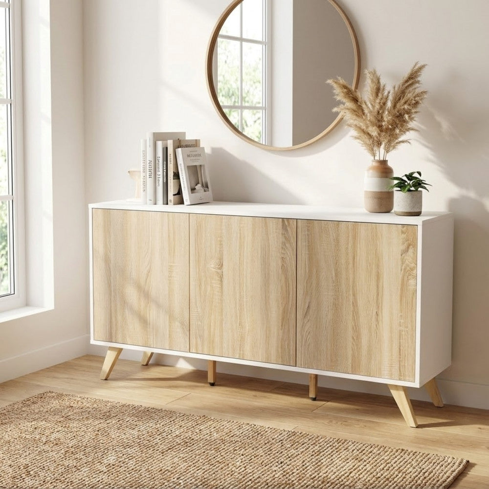 Credenza Elton decorata con uno specchio rotondo, libri e vasi, in un ingresso inondato di luce naturale.