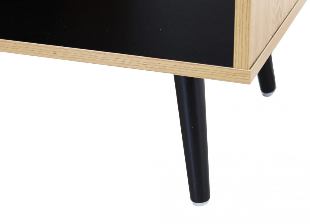 Dettaglio dei piedini affusolati neri che sostengono la struttura della credenza Elwood.