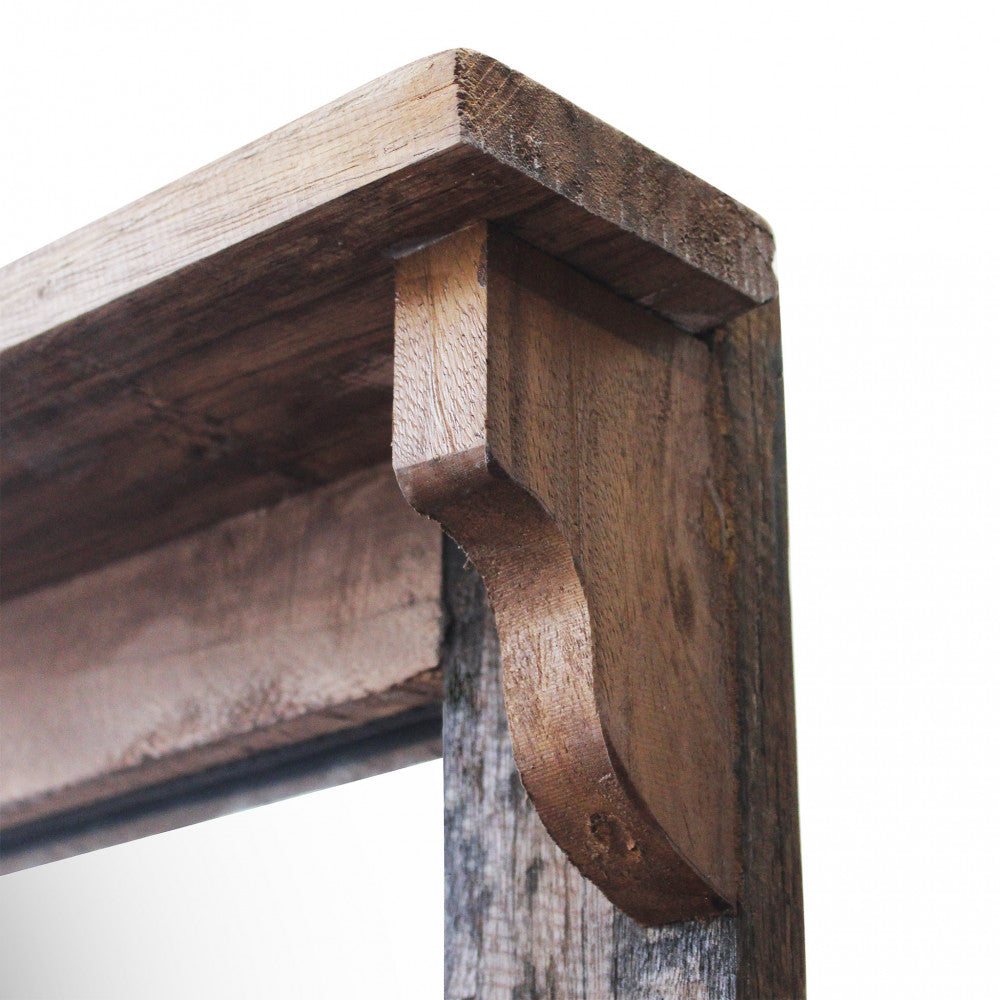 Dettaglio ravvicinato della cornice superiore in legno massiccio e del vetro riflettente.