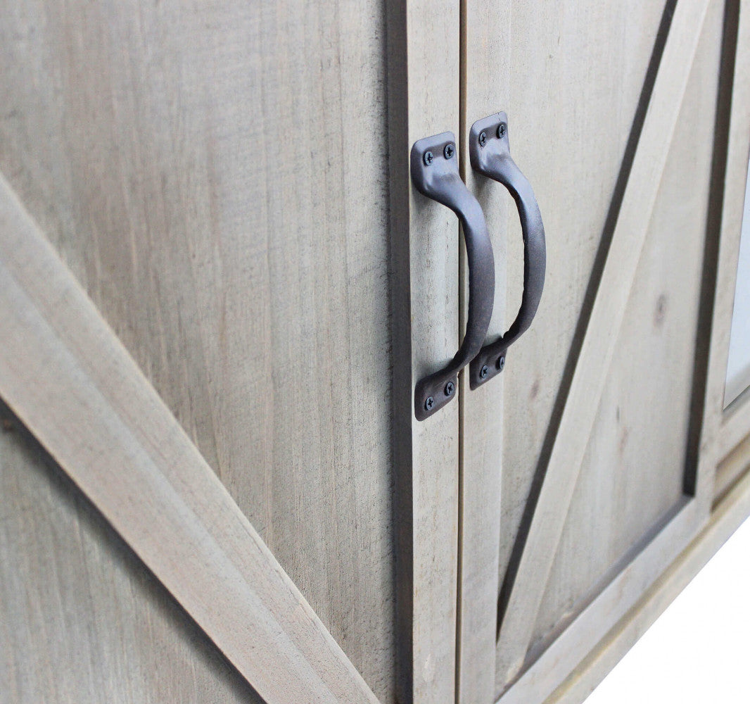 Dettaglio delle maniglie in metallo scuro sulle ante centrali in legno dal design a croce.