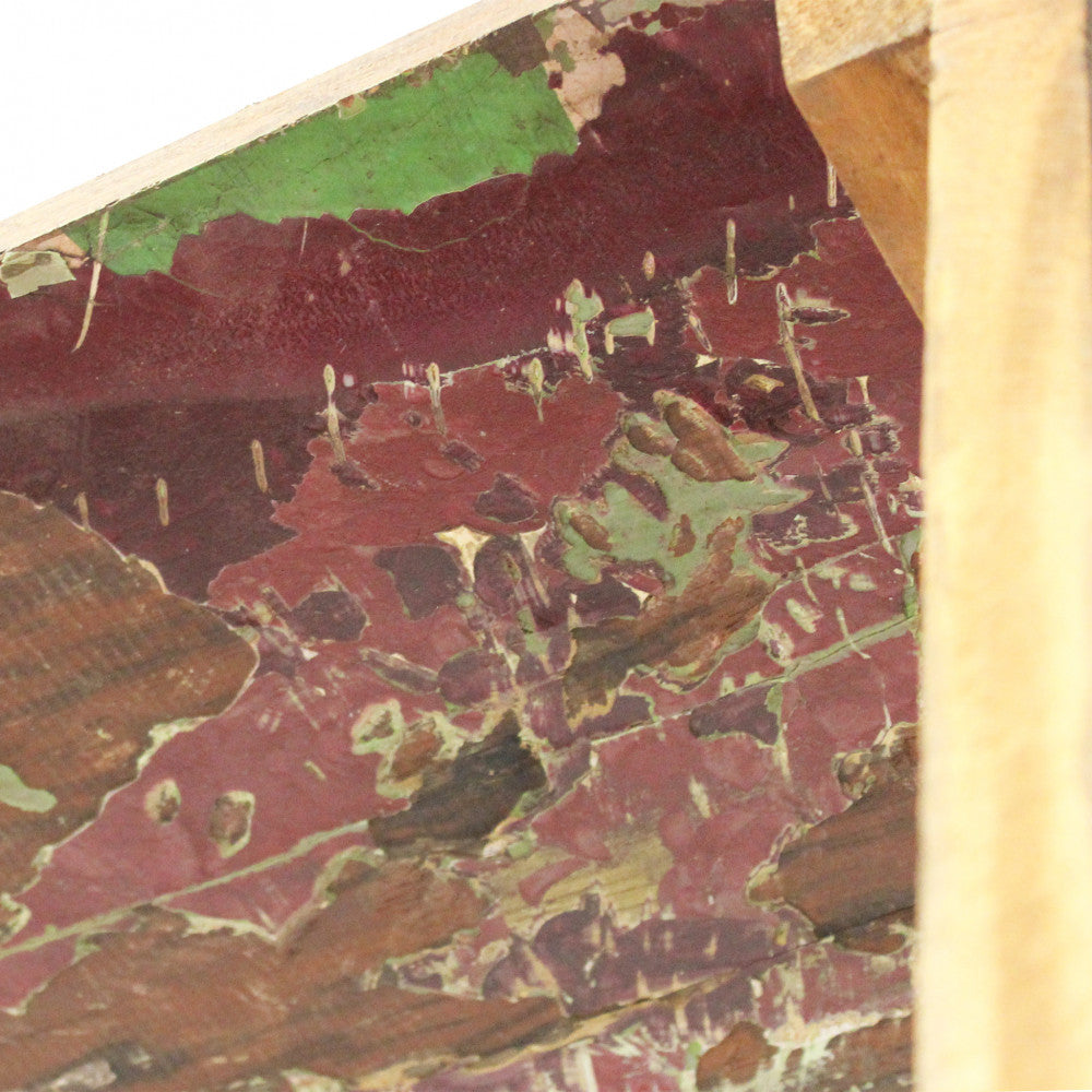 Particolare della superficie in legno di recupero con tracce di vernice originale scrostata.