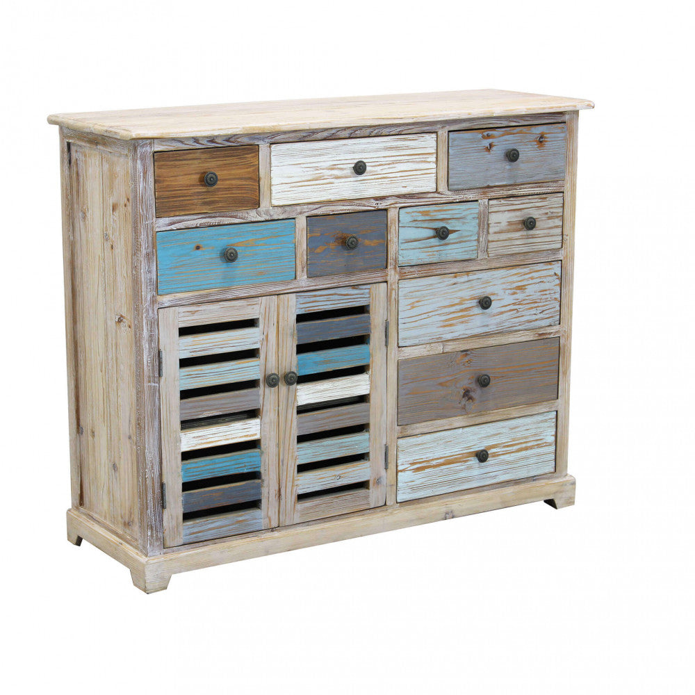 Vista angolare della credenza GREG con cassetti colorati e ante a persiana su sfondo bianco.