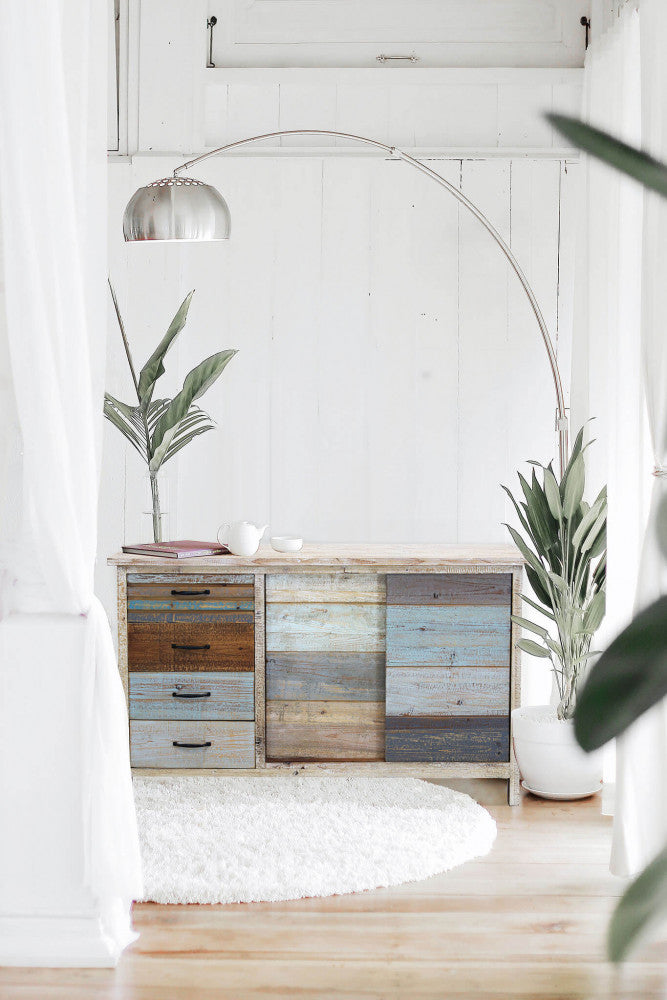 Credenza Harry inserita in un contesto d'arredo moderno con lampada ad arco e piante.