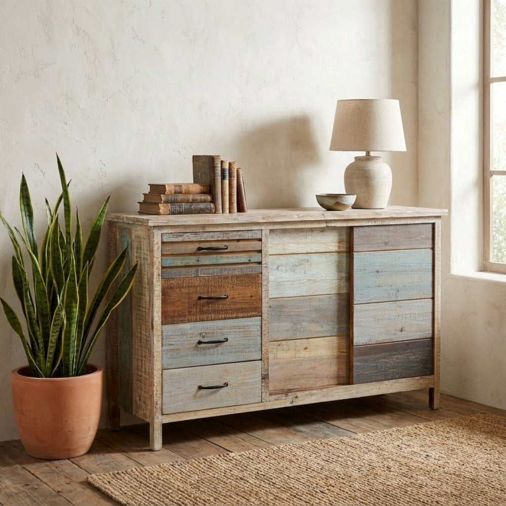 Ambientazione elegante con la credenza in legno accostata a una pianta d'appartamento e lampada da tavolo.