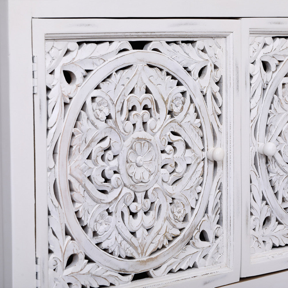 Primo piano degli intricati intagli circolari su legno di mango e pomelli bianchi.