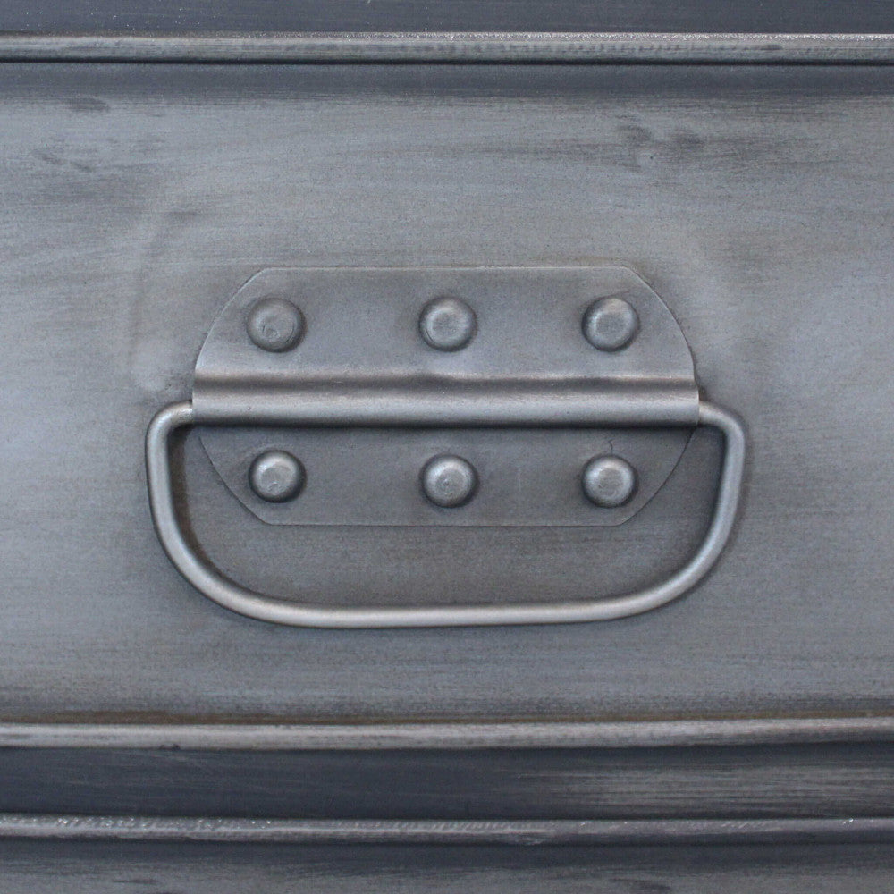 Particolare della maniglia a ribalta in metallo e dei rivetti decorativi sul cassetto.