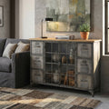 Credenza industriale Ernest in acciaio grigio antracite e legno ambientata in un soggiorno moderno con divano grigio.
