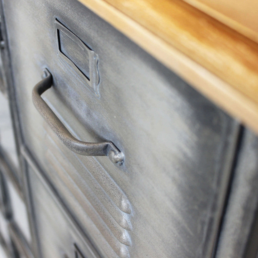 Primo piano della maniglia in metallo anticato e delle prese d'aria sui cassetti della credenza industriale Ernest.