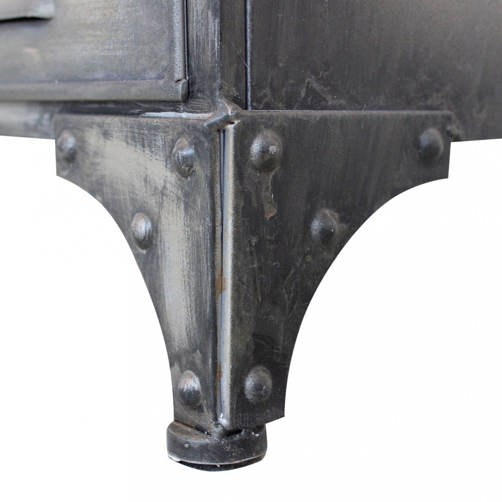 Dettaglio ravvicinato del piedino in acciaio rivettato della credenza Ernest, evidenziando la finitura grigio antracite.