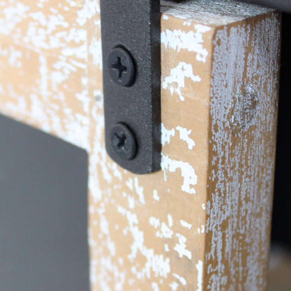 Particolare della ferramenta della credenza Florent, con focus sulle viti nere e sulla staffa in metallo che fissa l'anta in legno.