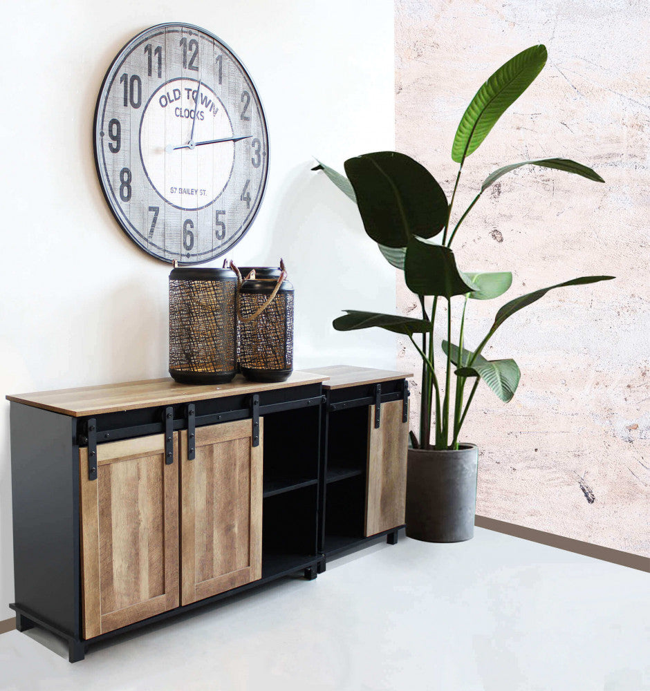 Coppia di credenze Xavier affiancate in un ampio living industriale, decorate con grandi lanterne e un orologio da parete vintage.