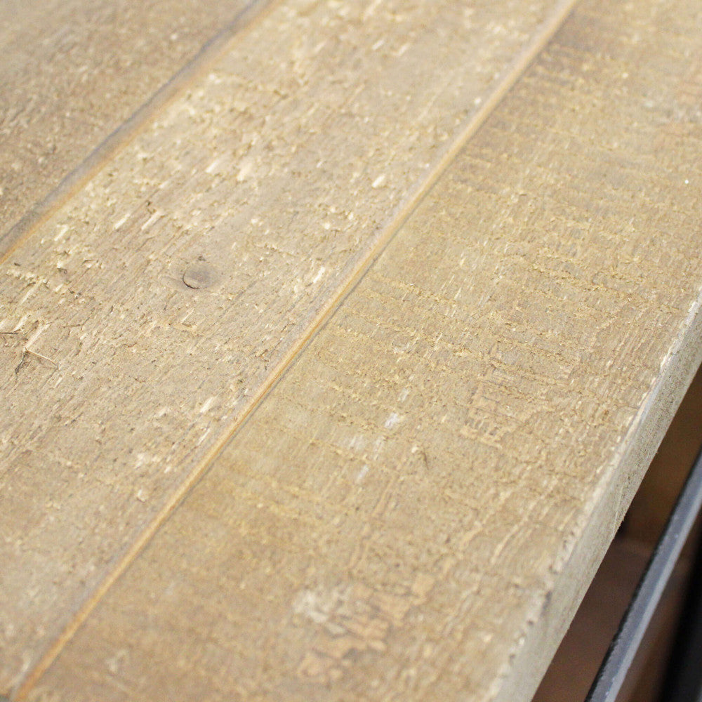 Primo piano della superficie in legno massiccio che mostra la texture ruvida e le venature naturali.