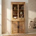 Credenza Julian in legno di mango chiaro, vista frontale in un salotto luminoso con poltrona neutra.