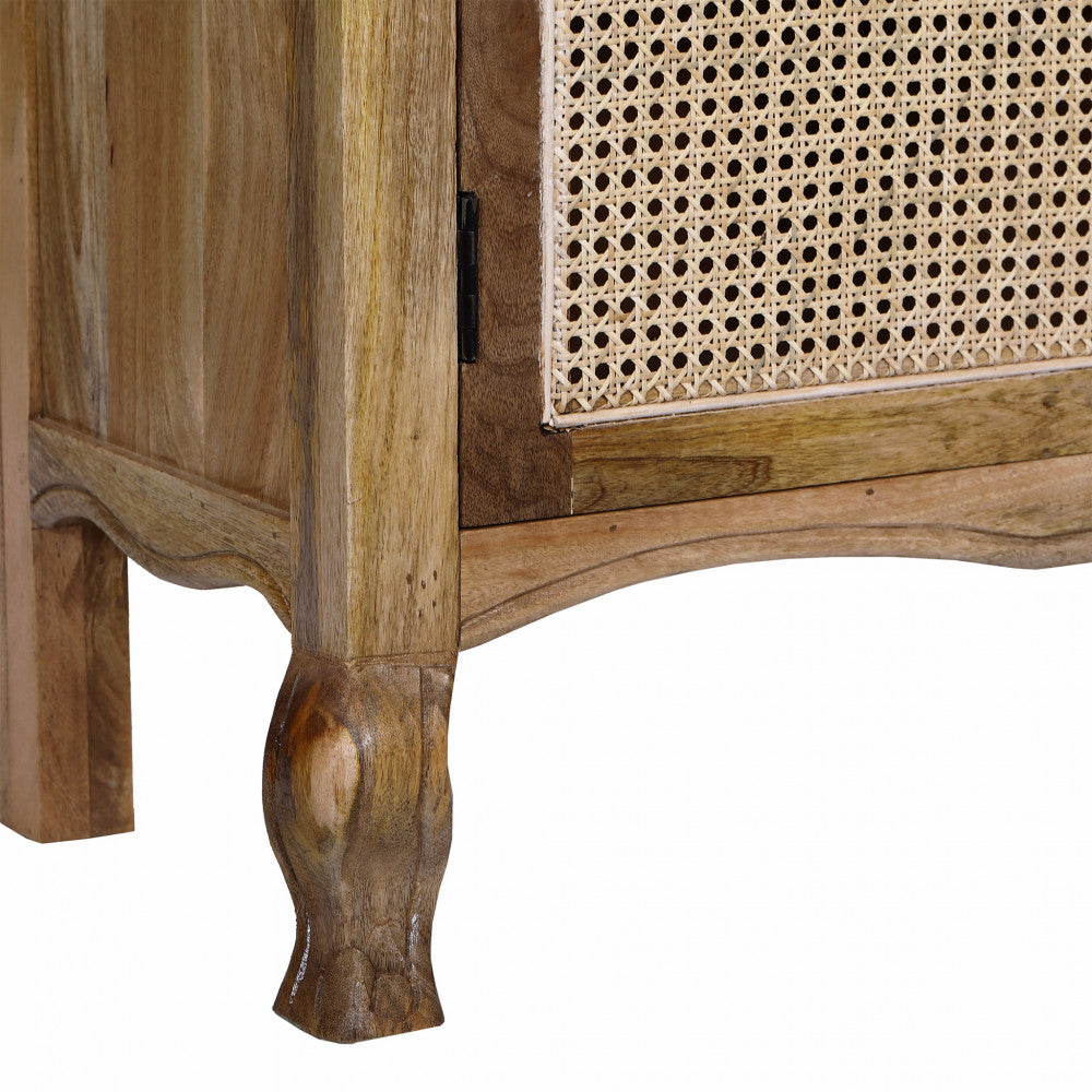 Dettaglio ravvicinato dei piedini intagliati e dell'anta inferiore in rattan intrecciato della Vetrina Kaleb.