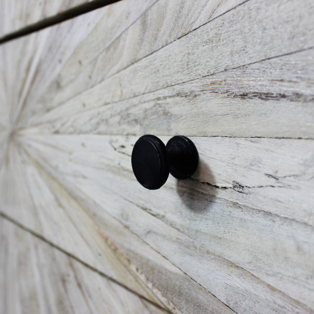 Dettaglio macro del pomello nero opaco e della texture ruvida e autentica del legno lavorato a raggiera.