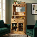 Mobile bar Lincoln in legno di mango ambientato in un salotto con poltrone in velluto verde.