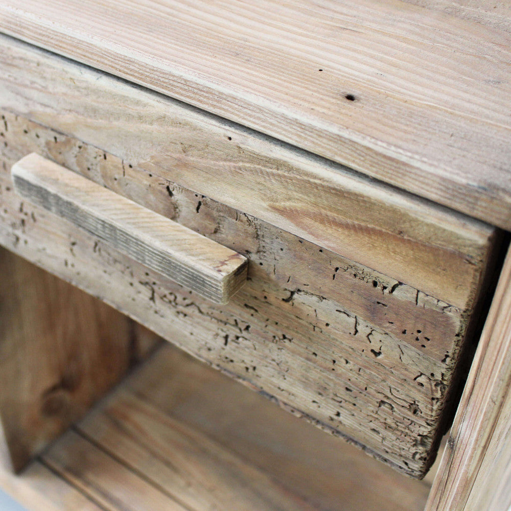 Primo piano del cassetto centrale in pino riciclato con maniglia in legno integrata e texture materica.