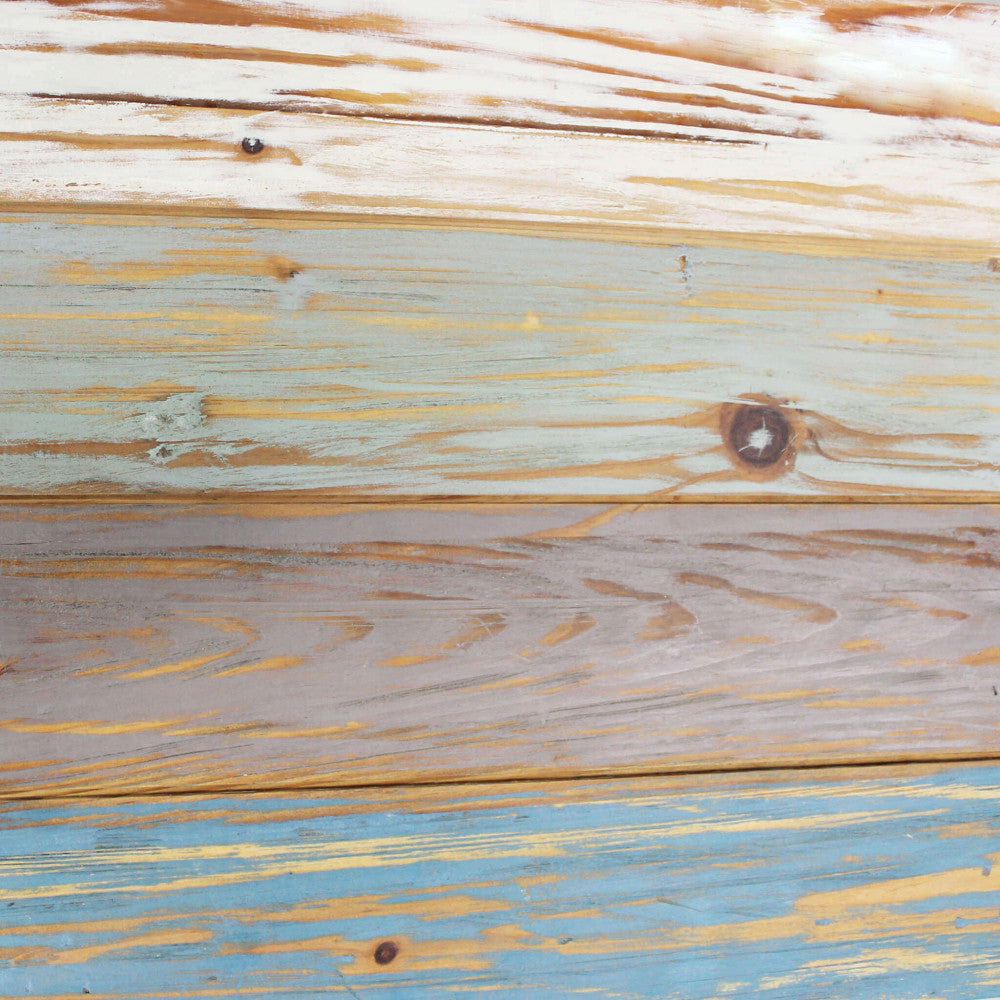 Dettaglio ravvicinato della texture in truciolare bilaminato multicolor, che simula assi di legno invecchiate nei toni del blu, bianco e marrone.