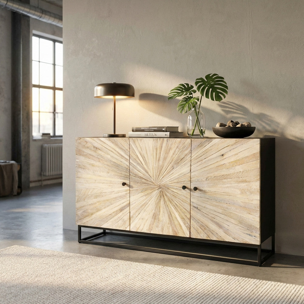 Vista frontale angolata della madia Spencer in legno chiaro e metallo nero, decorata con una pianta tropicale in un loft dal design industriale.
