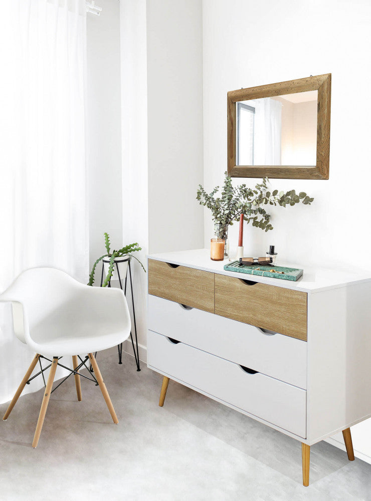 Cassettiera Terence inserita in un ingresso moderno con specchio in legno, sedia di design e piante decorative.