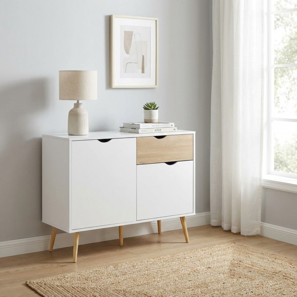 Credenza THEODORE posizionata in un corridoio luminoso con pavimento in legno, tappeto in iuta e quadri astratti alle pareti.