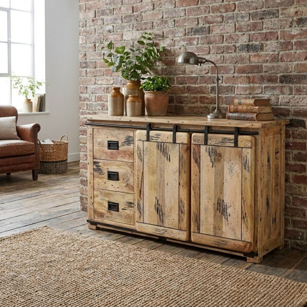 Credenza VERGIL in legno marrone ambientata in un loft dal design industriale, con parete in mattoni, tappeto in juta e poltrona in pelle.