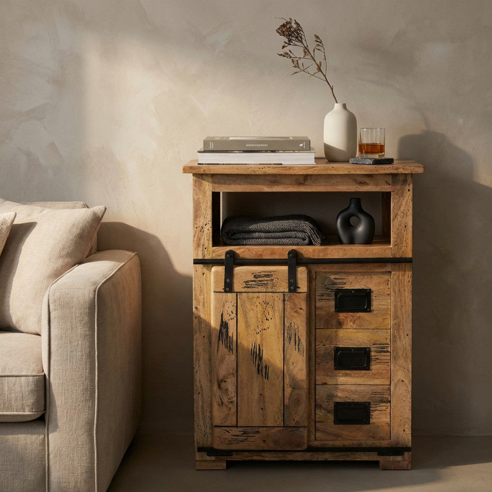 Dettaglio della credenza industriale Zacharias affiancata a un divano beige, decorata con vasi e libri.