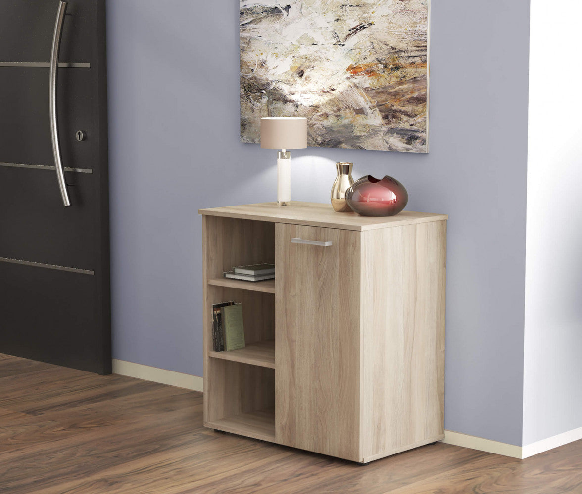 Mobiletto Mark posizionato in un corridoio elegante accanto a una porta scura, con lampada e vasi decorativi.