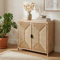 Mobiletto Carlos a due ante in legno di paulownia e corda intrecciata, ambientato in un salotto luminoso con vaso decorativo e pianta.