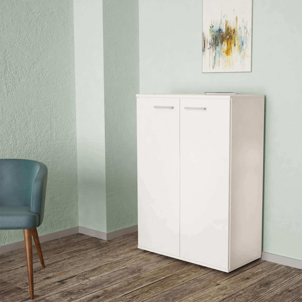 Mobiletto Riverbianco inserito in un contesto moderno con pareti verde salvia e una sedia di design.