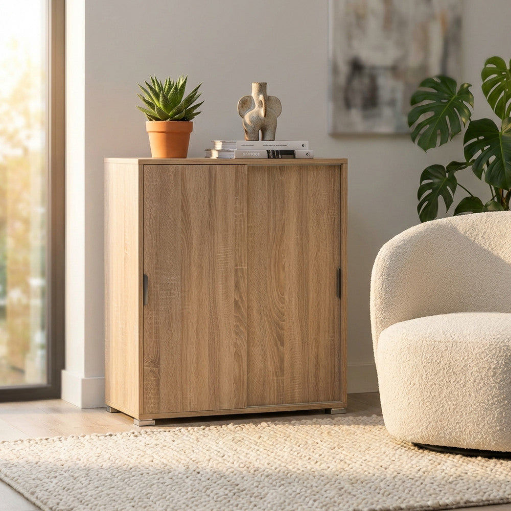Dettaglio del mobiletto chiuso con finitura naturale, decorato con una pianta e oggetti di design in un contesto moderno.