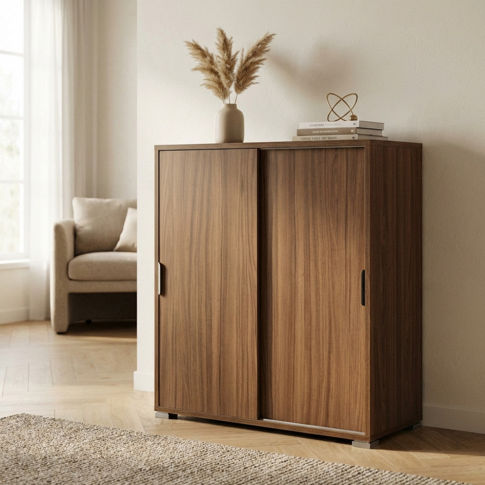 Mobiletto color noce posizionato in un ambiente luminoso, decorato con un vaso di pampas e dettagli di design minimalista.