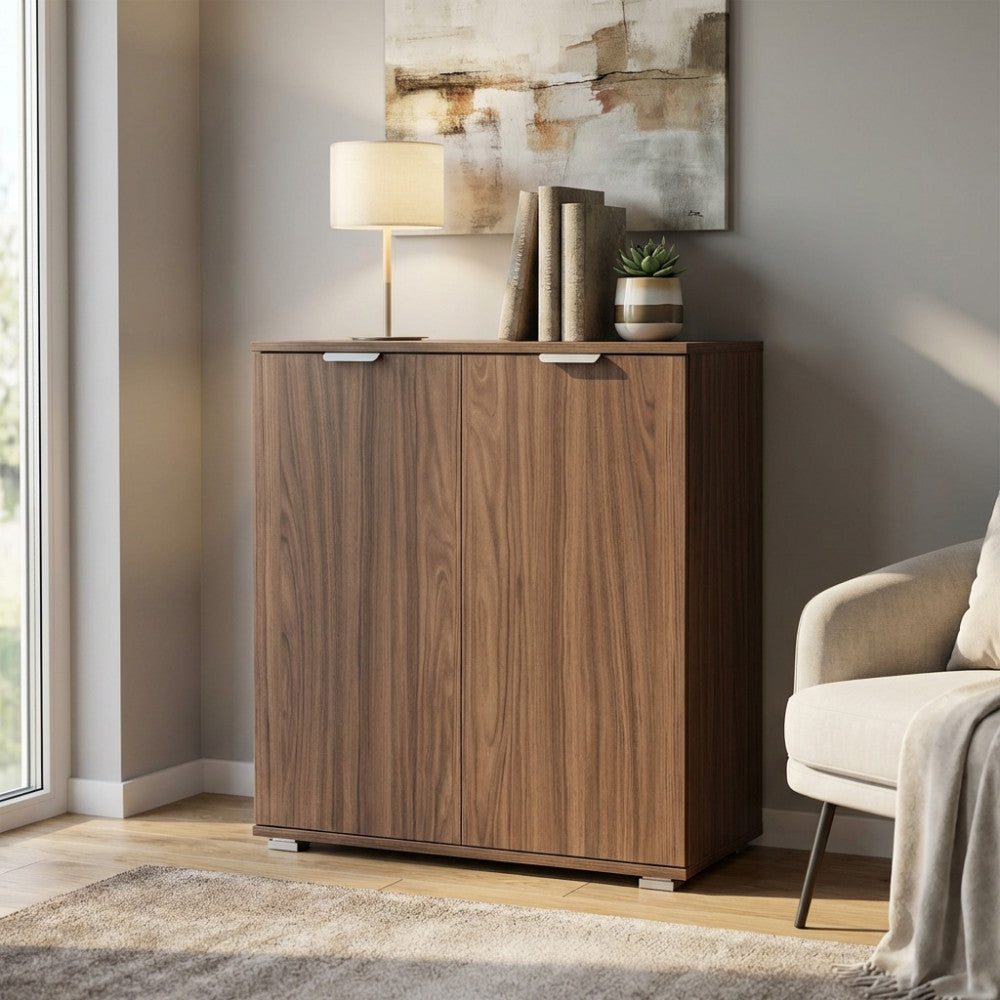 Vista angolare del mobiletto contenitore in finitura marrone noce, decorato con libri e una lampada da tavolo.